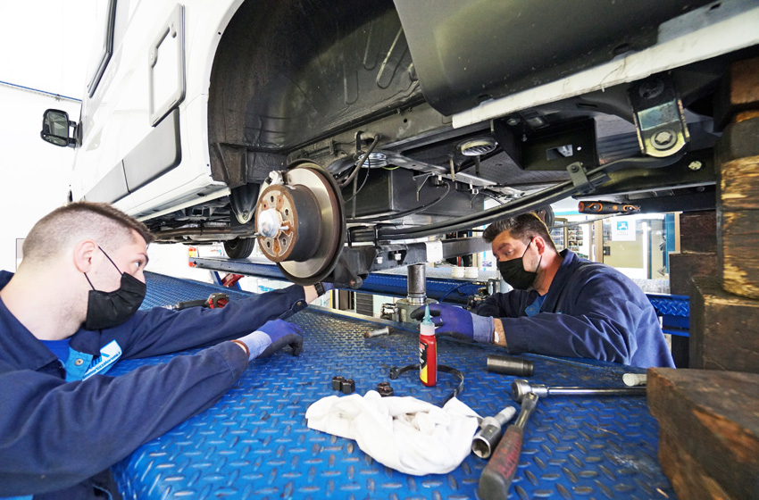 Lavoro di due operai sulle balestre di un camper. OMA-easy-comfort