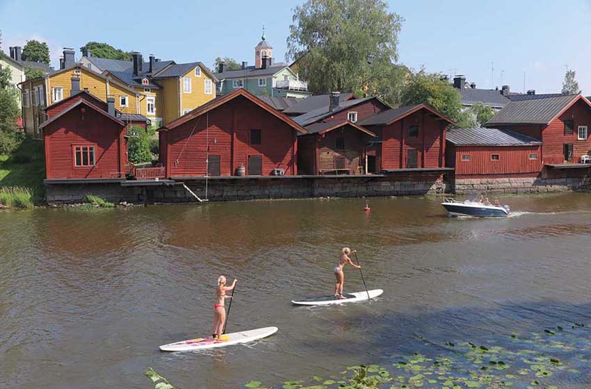 Finlandia-Porvoo-donne praticano  il sup-fiume-casette di legno colorate